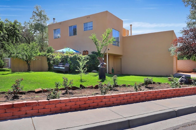 pueblo-style house with a front lawn