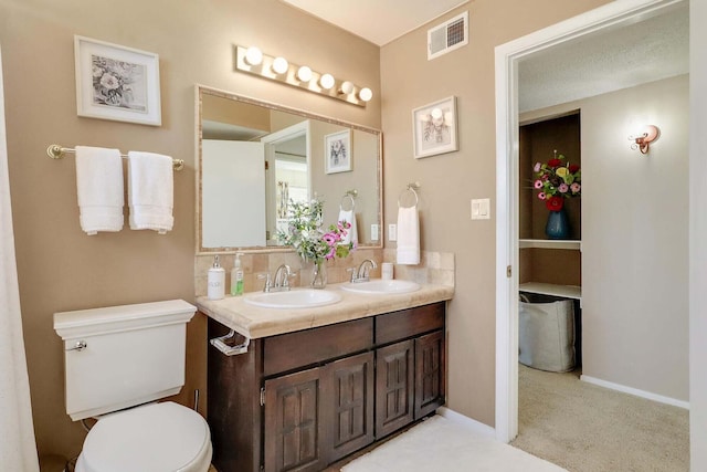 bathroom with vanity, a textured ceiling, and toilet