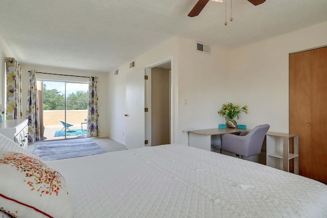 bedroom with access to exterior, a textured ceiling, and ceiling fan