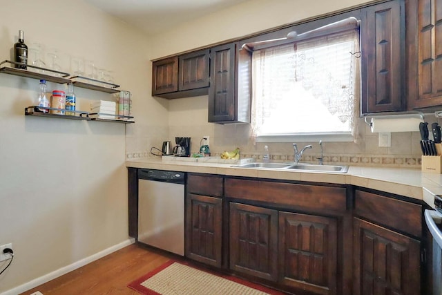 kitchen with decorative backsplash, dark brown cabinetry, sink, light hardwood / wood-style flooring, and dishwasher