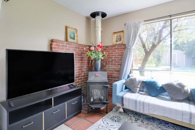 tiled living room featuring a wood stove and a textured ceiling