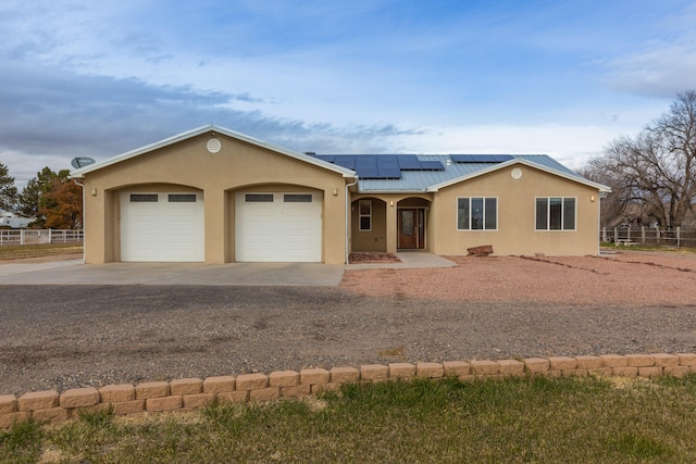 single story home with a garage and solar panels