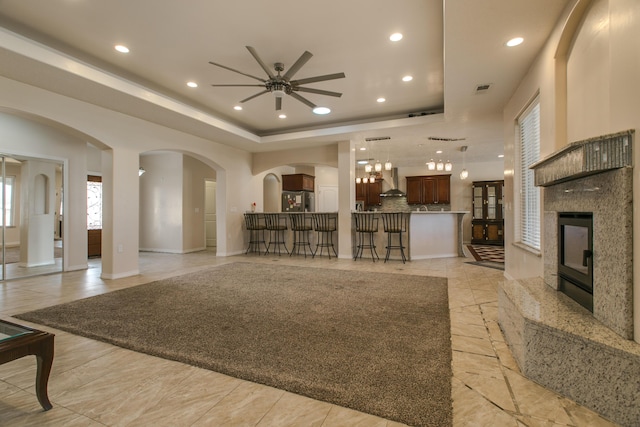 living room featuring a tray ceiling and a fireplace