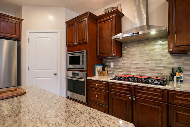 170 Esperanza Dr, Bosque Farms, NM 87068 - kitchen featuring wall chimney range hood, backsplash, light stone countertops, and appliances with stainless steel finishes
