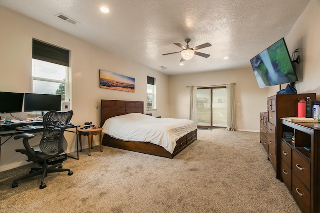 bedroom featuring light colored carpet, a textured ceiling, and ceiling fan