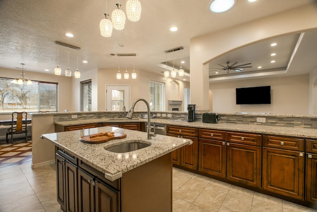 170 Esperanza Dr, Bosque Farms, NM 87068 - kitchen featuring a sink, light stone countertops, a center island with sink, ceiling fan with notable chandelier, and recessed lighting