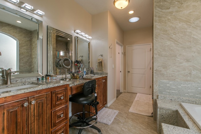 bathroom with vanity, tile patterned flooring, and a bathtub