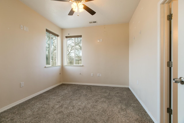 empty room featuring ceiling fan and dark colored carpet