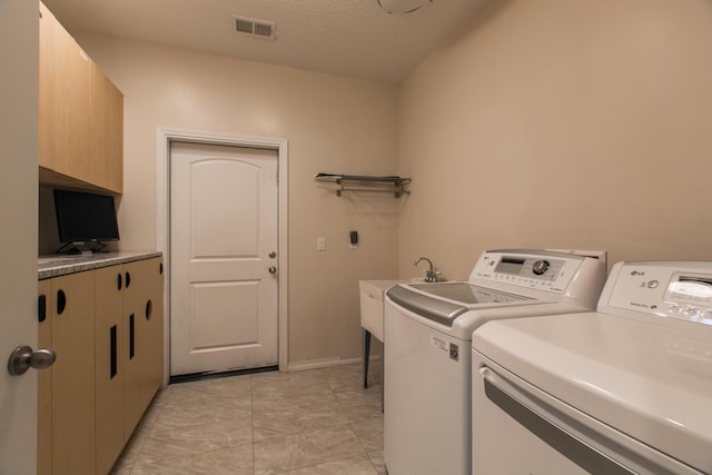 laundry area with cabinets, washer and clothes dryer, and sink