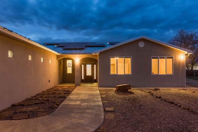 170 Esperanza Dr, Bosque Farms, NM 87068 - exterior space featuring stucco siding, metal roof, roof mounted solar panels, and a porch