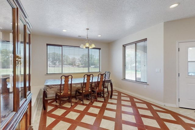 dining room with an inviting chandelier, light tile patterned floors, plenty of natural light, and a textured ceiling