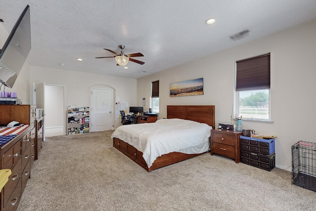 bedroom with light carpet, a textured ceiling, and ceiling fan