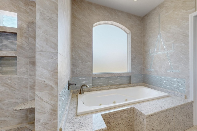 bathroom featuring tile walls and tiled tub