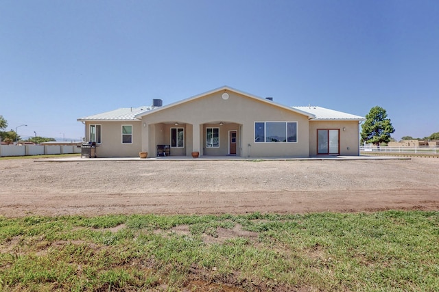 170 Esperanza Dr, Bosque Farms, NM 87068 - view of front of house with a standing seam roof, metal roof, stucco siding, and fence
