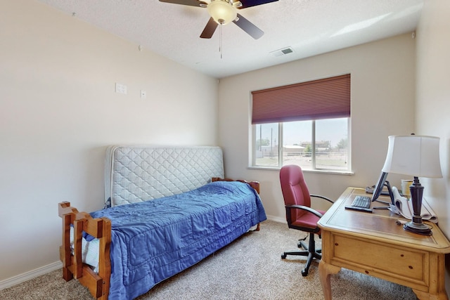 bedroom with ceiling fan, light carpet, and a textured ceiling