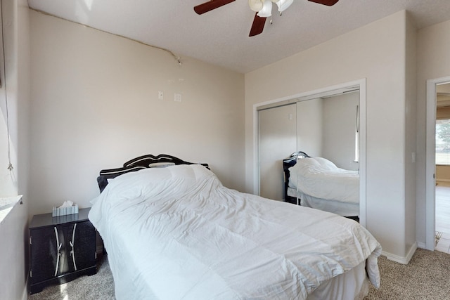 carpeted bedroom with ceiling fan and a closet