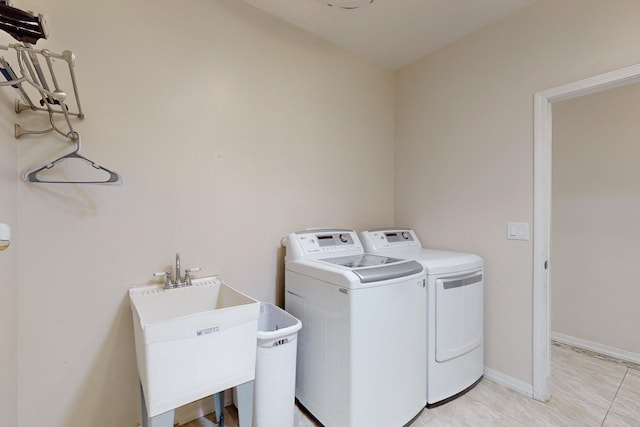 laundry area with washing machine and dryer, sink, and light tile patterned floors