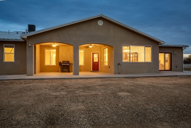 back house at dusk featuring central AC unit, a patio area, and ceiling fan