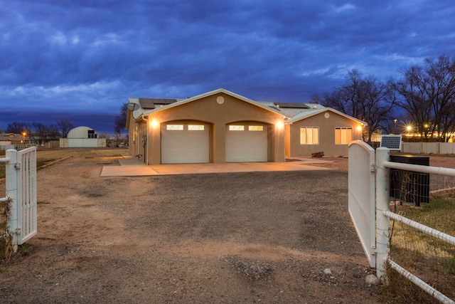 170 Esperanza Dr, Bosque Farms, NM 87068 - exterior space featuring a gate, an attached garage, solar panels, a fenced front yard, and dirt driveway
