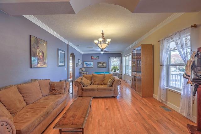 living room with hardwood / wood-style flooring, a healthy amount of sunlight, crown molding, and a textured ceiling