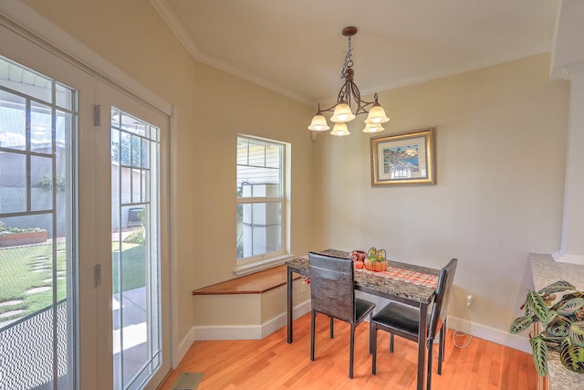 dining room with a chandelier, light hardwood / wood-style flooring, and crown molding