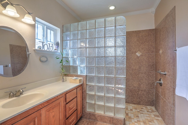 bathroom featuring a tile shower, vanity, tile patterned floors, and crown molding