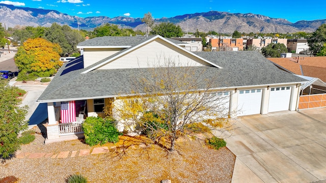 view of front facade with a mountain view, a porch, and a garage