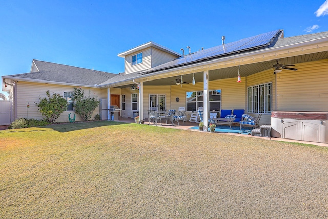 back of property featuring a lawn, a patio area, outdoor lounge area, and a hot tub