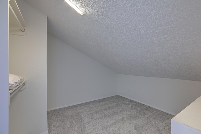 bonus room with carpet flooring, a textured ceiling, and vaulted ceiling