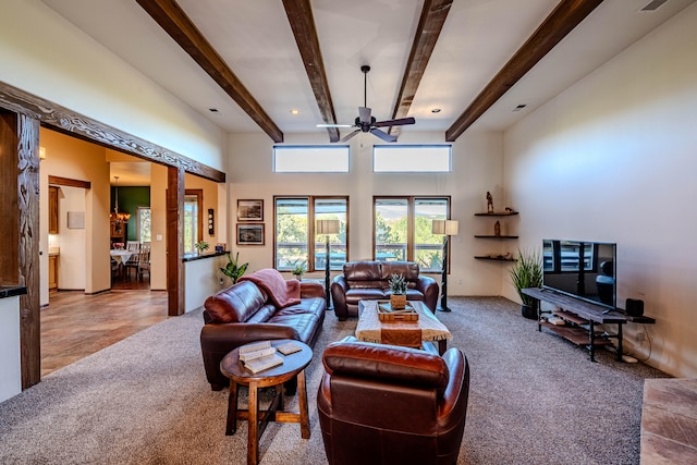 living room featuring carpet, ceiling fan, beamed ceiling, and a high ceiling