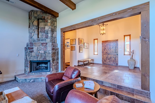 living room with beamed ceiling, a fireplace, and a chandelier