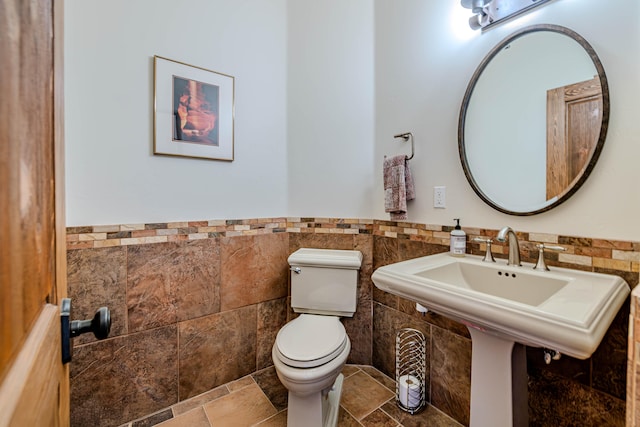 bathroom with tile walls and toilet