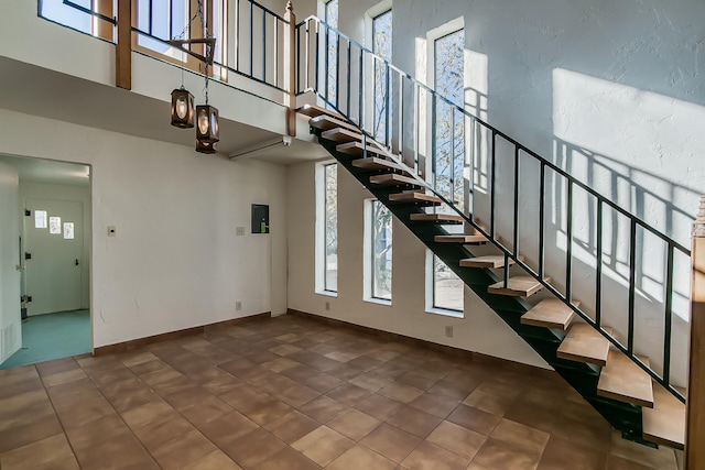 staircase featuring plenty of natural light and a towering ceiling