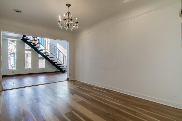 unfurnished living room with a chandelier and dark wood-type flooring