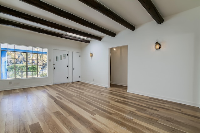 unfurnished living room with hardwood / wood-style floors and beamed ceiling