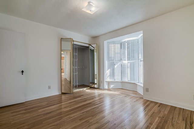 unfurnished bedroom with hardwood / wood-style floors