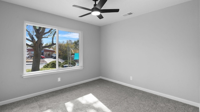 unfurnished room featuring carpet floors, a wealth of natural light, and ceiling fan