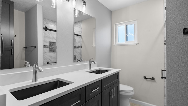 bathroom featuring vanity, a shower with shower door, and toilet