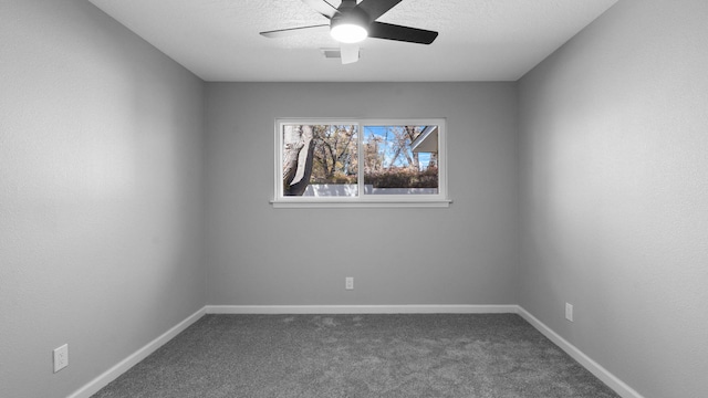 spare room featuring dark carpet and ceiling fan