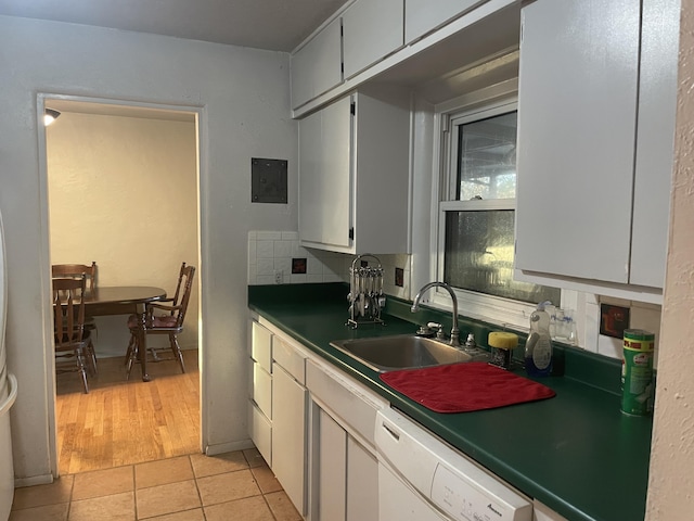 kitchen with dishwasher, sink, light tile patterned floors, backsplash, and white cabinets