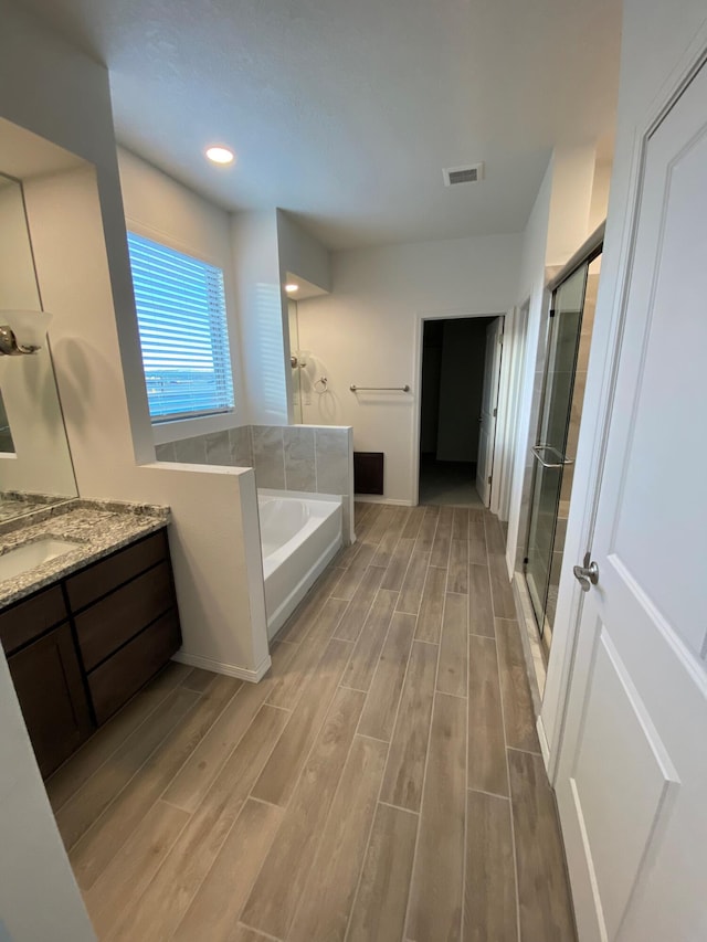 bathroom featuring separate shower and tub and vanity