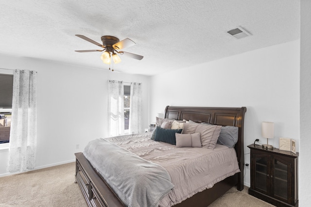 bedroom featuring ceiling fan, light carpet, and a textured ceiling