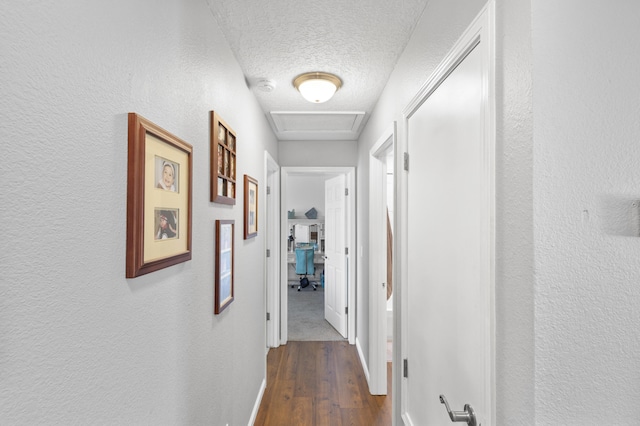 hallway with dark hardwood / wood-style flooring and a textured ceiling