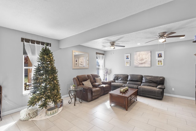 living room featuring ceiling fan and a textured ceiling