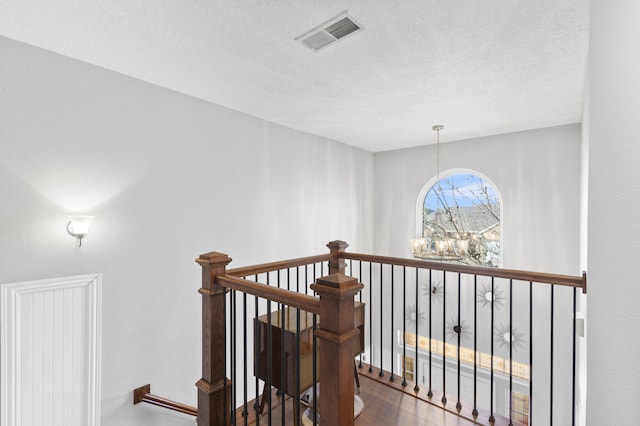 corridor with hardwood / wood-style flooring and a textured ceiling