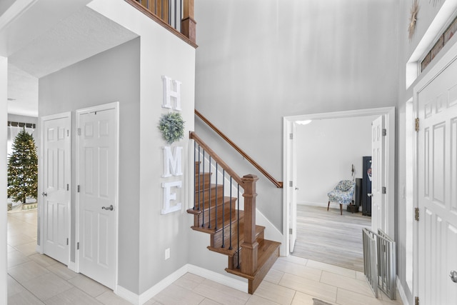 tiled entryway featuring a towering ceiling