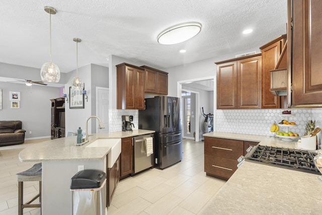 kitchen featuring appliances with stainless steel finishes, sink, a textured ceiling, and decorative backsplash