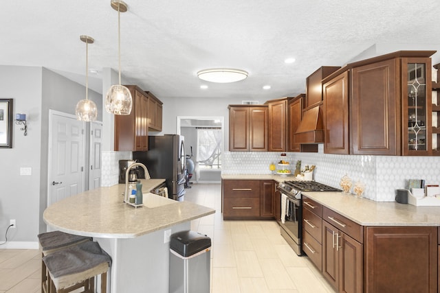 kitchen with custom exhaust hood, tasteful backsplash, a kitchen breakfast bar, pendant lighting, and stainless steel appliances