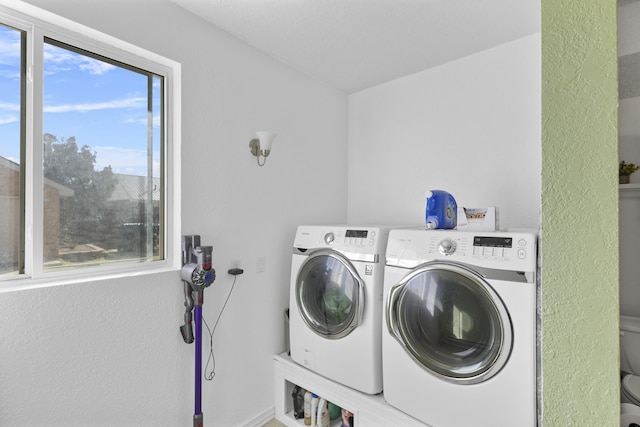 laundry room with washing machine and clothes dryer and a healthy amount of sunlight