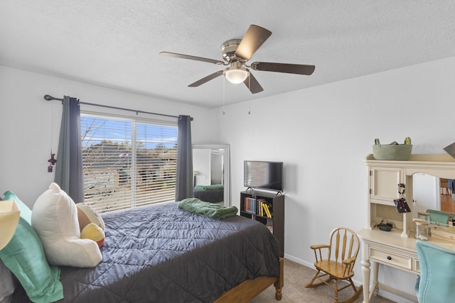 bedroom with a textured ceiling, ceiling fan, and carpet